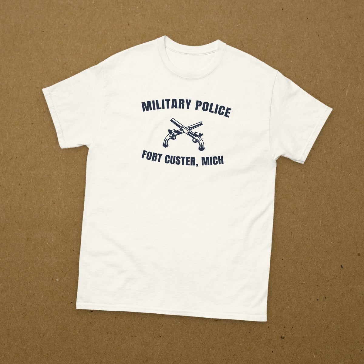T-shirt blanc imprimé Military Police Fort Custer, Michigan, aux pistolets croisés, reproduction WW2, à plat sur fond kraft